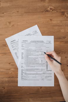 木桌上手写海关申报表 Hand writing tax forms on wood table.