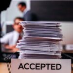 办公室中一堆贴有“已接受”标签的文件 Pile of papers with 'Accepted' label.