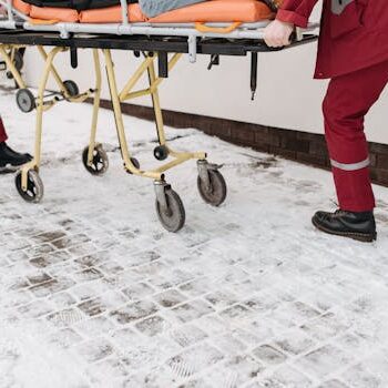 两名护理人员在雪地中推担架 Two paramedics moving stretcher on snow.