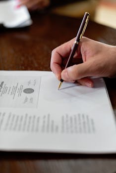 签署文件 Signing Document 手签正式文件的特写 Hand signing formal document close-up.